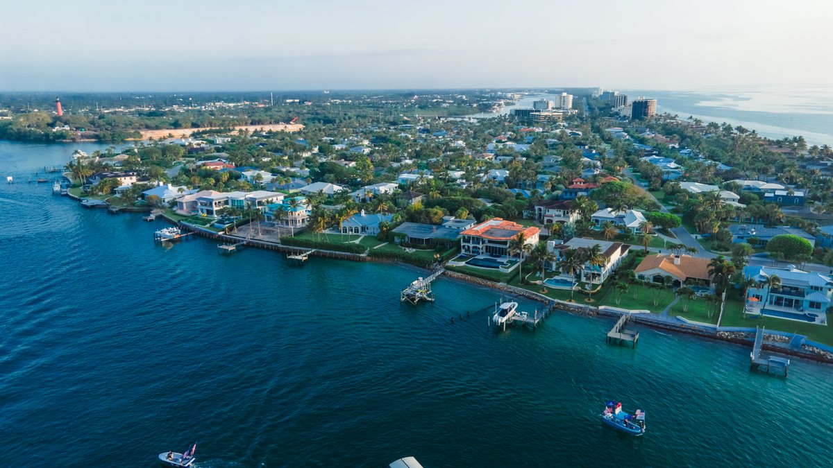 The Jupiter Inlet from the air, with the lighthouse point, the sandbar and boats on the turquoise channel