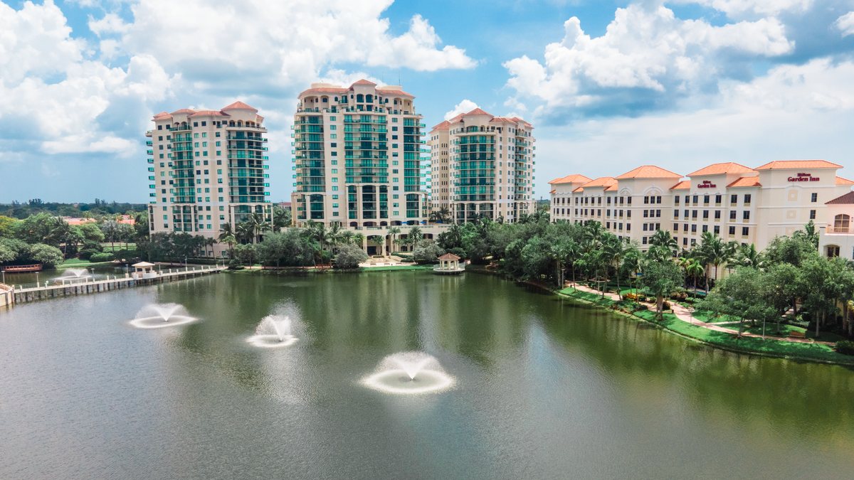 The Downtown Palm Beach Gardens towers reflected in the lake, fountains in the foreground